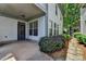 View of the paved back patio area with entrance into the house with well-kept landscaping at 375 Causeway Ct, Suwanee, GA 30024