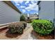Beautiful landscaped backyard with neatly trimmed bushes and brick pavers leading to grass at 375 Causeway Ct, Suwanee, GA 30024