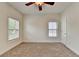 Bright bedroom featuring neutral carpet, two windows with blinds, and a ceiling fan at 375 Causeway Ct, Suwanee, GA 30024