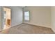 A cozy bedroom with carpet flooring and natural light from a window at 375 Causeway Ct, Suwanee, GA 30024