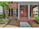 Inviting front porch with brick columns, a red door, and manicured landscaping at 375 Causeway Ct, Suwanee, GA 30024