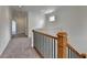 Upstairs hallway featuring carpet flooring, wood and iron railing, and natural lighting at 375 Causeway Ct, Suwanee, GA 30024