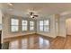 Bright living room features hardwood floors, large windows, ceiling fan, and neutral paint at 375 Causeway Ct, Suwanee, GA 30024