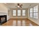 Open living area with fireplace, built-ins, hardwood floors, and multiple windows for natural light at 375 Causeway Ct, Suwanee, GA 30024