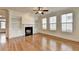 Spacious living room with hardwood floors, fireplace, built-in shelving, and large windows at 375 Causeway Ct, Suwanee, GA 30024