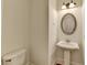 Charming powder room showcasing a pedestal sink, oval mirror, and decorative lighting at 375 Causeway Ct, Suwanee, GA 30024