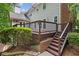 Inviting outdoor space featuring a spacious wood deck and staircase leading to a landscaped yard with mature trees at 420 Windswept Ct, Roswell, GA 30075