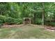 Picturesque backyard featuring lush greenery, a wooden arbor, and a well-manicured lawn surrounded by mature trees at 420 Windswept Ct, Roswell, GA 30075