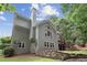 Charming exterior showcasing a well-maintained yard, stone retaining wall, and multiple windows for ample natural light at 420 Windswept Ct, Roswell, GA 30075