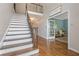 Spacious foyer featuring hardwood floors, a staircase with wrought iron railings, and elegant trim at 420 Windswept Ct, Roswell, GA 30075