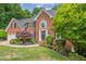 Attractive brick home featuring lush landscaping, a manicured lawn, and mature trees for added privacy at 420 Windswept Ct, Roswell, GA 30075