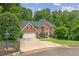 Beautiful brick home with manicured landscaping and mature trees surrounding the property on a cul-de-sac at 420 Windswept Ct, Roswell, GA 30075