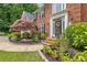 Inviting front porch showcasing colorful plantings, beautiful landscaping, and a stately brick facade at 420 Windswept Ct, Roswell, GA 30075