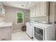 Bright laundry room features a washer, dryer, and ample storage, perfect for efficient home management at 420 Windswept Ct, Roswell, GA 30075