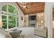 Bright living room with vaulted ceilings, fireplace, and large windows offering views of the backyard at 420 Windswept Ct, Roswell, GA 30075
