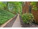 Brick home featuring a tranquil walkway surrounded by lush greenery, enhancing its curb appeal at 420 Windswept Ct, Roswell, GA 30075