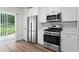 Charming kitchen with stainless steel appliances, white cabinetry, and access to outdoor living space at 11255 Wittenridge Dr, Alpharetta, GA 30022