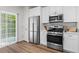 Contemporary kitchen with stainless steel appliances and white cabinets and sliding glass door at 11255 Wittenridge Dr, Alpharetta, GA 30022