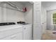 Convenient laundry room with modern washer and dryer units and storage shelf at 11255 Wittenridge Dr, Alpharetta, GA 30022