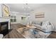 Cozy living room features a fireplace, hardwood floors, and a comfortable sofa near a window at 11255 Wittenridge Dr, Alpharetta, GA 30022