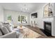 Comfortable living room features a fireplace, hardwood floors, a modern chandelier, and natural light at 11255 Wittenridge Dr, Alpharetta, GA 30022