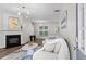 Bright living room with a fireplace, hardwood floors, modern lighting, and comfortable white sofa at 11255 Wittenridge Dr, Alpharetta, GA 30022