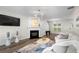 Inviting living room featuring a fireplace, modern chandelier, hardwood floors, and a comfortable white sofa at 11255 Wittenridge Dr, Alpharetta, GA 30022