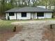 Charming home featuring black trim, white siding, and a large gravel driveway at 12778 Cumming Hwy, Canton, GA 30115
