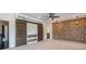 Spacious bedroom with brick accent wall, sliding barn doors, and modern ceiling fan at 2370 Bradwardine Ct, Cumming, GA 30041