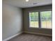 Neutral bedroom with two large windows providing lots of natural light, and plush carpet at 2409 Malster Ln, Lawrenceville, GA 30043