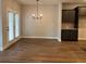 Inviting dining area boasts hardwood floors, elegant chandelier, and dark cabinetry with stone countertops at 2409 Malster Ln, Lawrenceville, GA 30043