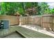 Fenced backyard featuring a wood deck and an AC unit amid green trees at 3200 Seven Pines Ct # 103, Atlanta, GA 30339