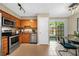 Galley kitchen featuring stainless steel appliances, wooden cabinets, and adjacent dining space with sliding glass door at 3200 Seven Pines Ct # 103, Atlanta, GA 30339