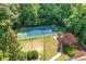 Aerial view of a blue and green tennis court surrounded by lush trees and landscaping at 3200 Seven Pines Ct # 103, Atlanta, GA 30339