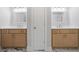Bathroom featuring double vanities with wooden cabinets, mirrors, and hardware at 3902 Bouldercrest Se Rd, Ellenwood, GA 30294