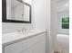 Bright bathroom features white cabinets, white countertops, and a framed mirror at 3902 Bouldercrest Se Rd, Ellenwood, GA 30294