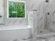 Bathroom featuring a separate tub and shower with sleek marble tile at 3902 Bouldercrest Se Rd, Ellenwood, GA 30294