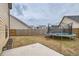 Large backyard with a trampoline, privacy fence, and patio area at 1262 Brookstone Cir, Conyers, GA 30012