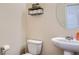 Half bathroom featuring a toilet, sink, round mirror, and toilet paper holder at 1262 Brookstone Cir, Conyers, GA 30012