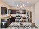 Well-lit kitchen features dark cabinetry, stainless steel appliances, granite countertops, and an adjacent dining area at 1262 Brookstone Cir, Conyers, GA 30012