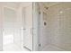 Bright bathroom featuring tiled shower with glass door, and a walk-in closet with shelving at 213 Admor Ln, Acworth, GA 30102