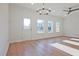 Bright living room with hardwood floors, modern lighting, three large windows, and an exterior door at 213 Admor Ln, Acworth, GA 30102