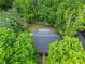 Aerial shot shows a backyard featuring pea gravel and grass surrounded by lush trees at 2565 Bates Se St, Smyrna, GA 30080