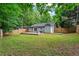 Large backyard featuring a pea gravel patio, grass, wooden deck, and fencing at 2565 Bates Se St, Smyrna, GA 30080