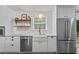 Well-lit kitchen features white cabinets, stainless appliances, floating shelves and a large farmhouse sink at 2565 Bates Se St, Smyrna, GA 30080