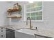 Close up on the farmhouse sink and window with granite counters and stainless dishwasher at 2565 Bates Se St, Smyrna, GA 30080