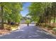Driveway entrance with a gated entrance to the community, surrounded by mature trees at 2690 Derby Ne Walk # 53, Atlanta, GA 30319