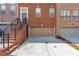 Brick townhome featuring a private garage and a welcoming entryway with a staircase at 2690 Derby Ne Walk # 53, Atlanta, GA 30319