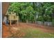 Large, partially fenced backyard with a wooden deck and mature trees at 2746 Sanibel Se Ln, Smyrna, GA 30082