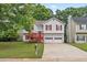 Charming home with red shutters, a two-car garage, mature trees, and a quaint, covered front porch at 2746 Sanibel Se Ln, Smyrna, GA 30082